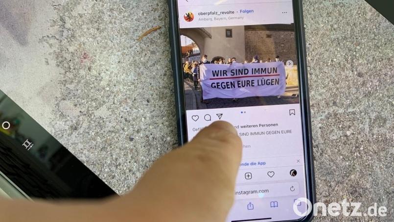 Ein Handy liegt auf der Straße. Der Bildschirm zeigt den Instagram-Auftritt der &quot;Identitären Bewegung&quot; und ein Foto, das während des Coronaprotestes am 13. Februar in Amberg gemacht wurde. Dort hatten sich die Rechtsextremen mit ihrem Banner zeitweise an der Spitze des Zuges positioniert. Bild: roa