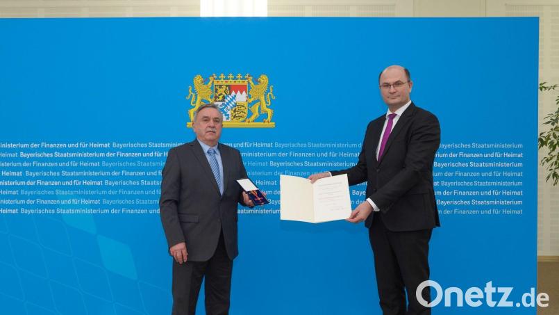 Finanz- und Heimatminister Albert Füracker (rechts) überreicht das Bundesverdienstkreuz am Bande an Boris Damzog. Bild: StMFH/exb