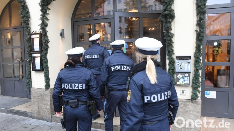 Polizeibeamte gehen bei einem Pressetermin zu Corona-Kontrollen in München in ein Restaurant, um dort vor den Augen der Medien die Einhaltung der Corona-Regeln zu überprüfen. Symbolbild: Felix Hörhager/dpa