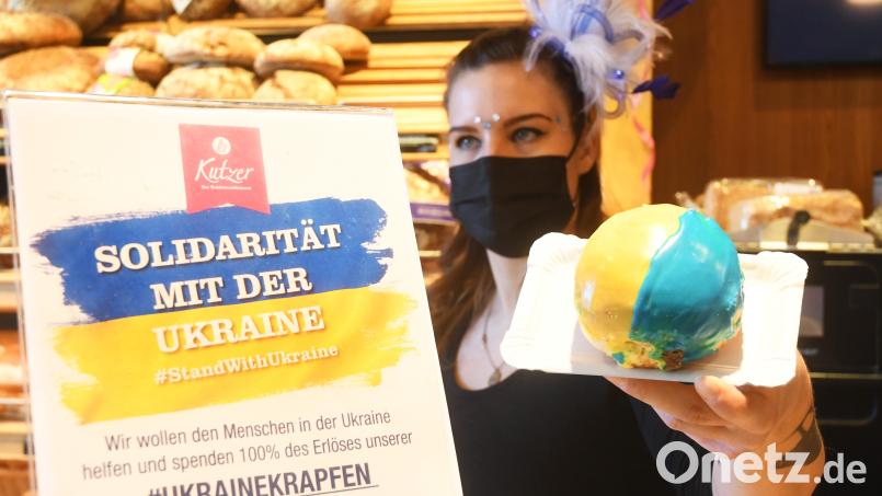 Eine Mitarbeiterin in einer Kutzer-Filiale zeigt einen der gefragten Ukraine-Krapfen. Schon am Nachmittag waren kaum noch welche zu bekommen. Bild: Gabi Schönberger