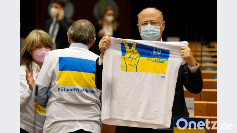 Ein Mitglied des Europäischen Parlaments hält ein T-Shirt in den Farben Blau und Gelb zur Unterstützung der Ukraine. Bild: Virginia Mayo/AP/dpa
