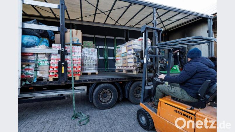 Ein Helfer lädt eine Europalette auf einen Lastwagen. Bild: Matthias Balk/dpa