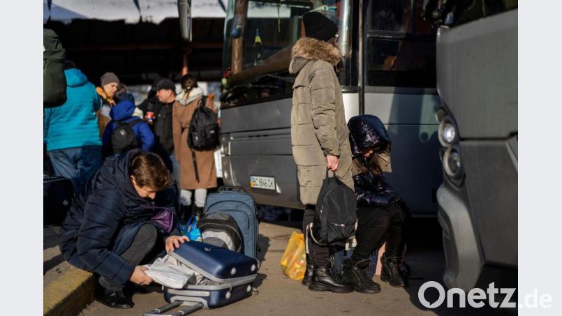Ukrainische Bürger bereiten sich an einem Bahnhof im Westen der Ukraine vor, in einen Bus nach Polen einzusteigen. Bild: Bernat Armangue/AP/dpa