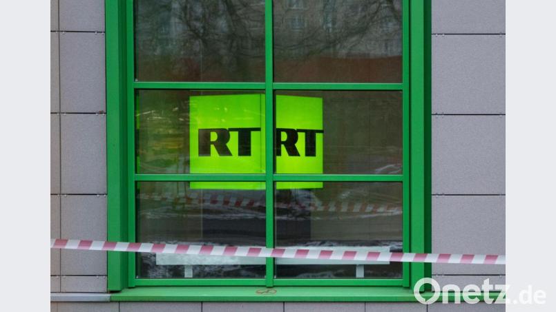 Das Logo des staatlichen russischen TV-Senders RT ist im Fenster des Firmenbüros zu sehen. Bild: Pavel Golovkin/AP/dpa
