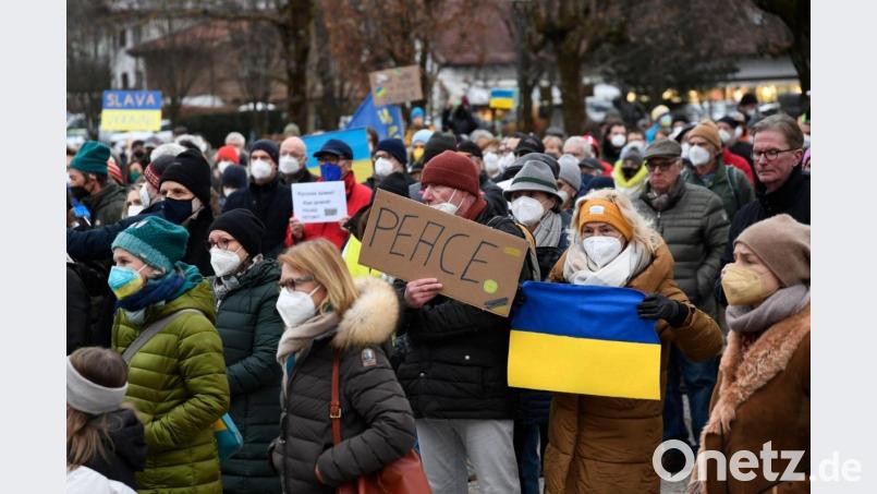 Teilnehmer einer Demo gegen den Ukraine-Krieg stehen am Wohnort des russischen Oligarchen Alischer Usmanow. Bild: Uwe Lein/dpa