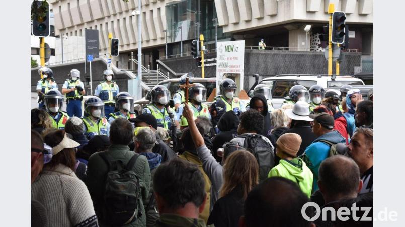 Demonstranten, die gegen das Impfmandat protestieren, stehen vor dem Parlamentsgebäude in Wellington. Bild: Ben Mckay/AAP/dpa