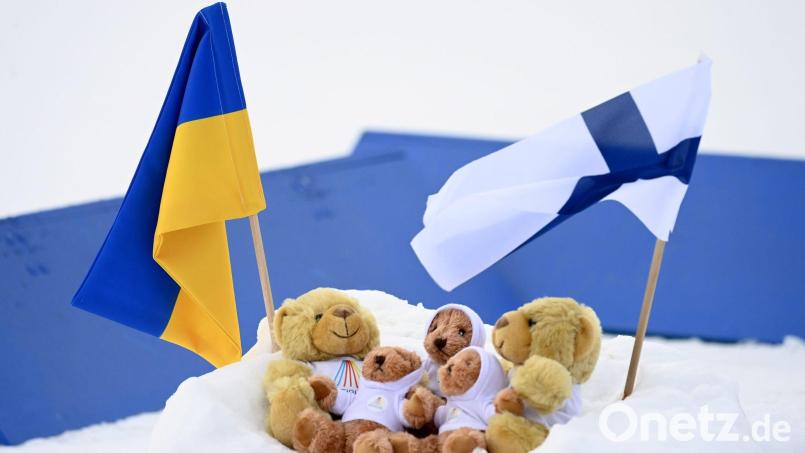 Fahnen der Ukraine und Finnlands in Kontiolahti neben den Weltcup-Maskottchen im Schnee. Bild: Vesa Moilanen/Lehtikuva/dpa