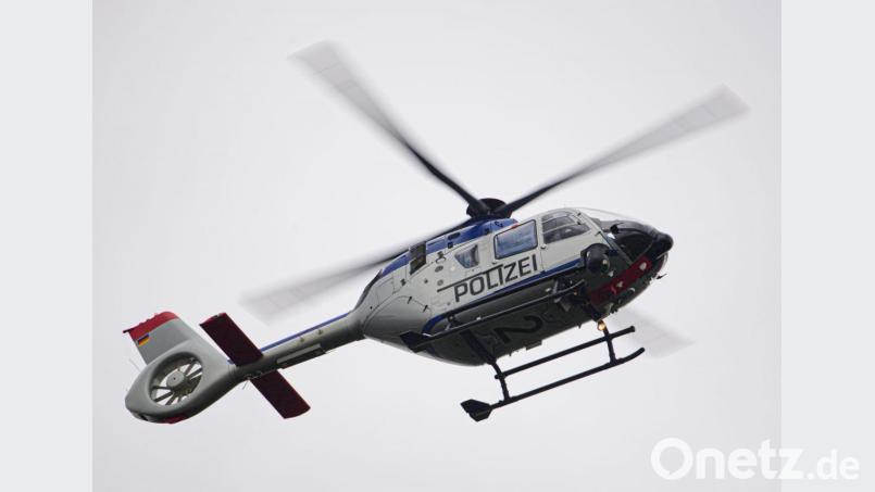 Ein Polizeihubschrauber fliegt bei einem Sucheinsatz über eine Stadt. Bild: Robert Michael/dpa-Zentralbild/ZB/Symbolbild