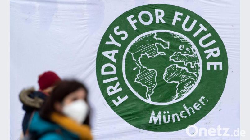 Teilnehmer einer Kundgebung von Fridays for Future (fff) stehen im Olympiapark vor einem Banner. Bild: Sven Hoppe/dpa/Archivbild