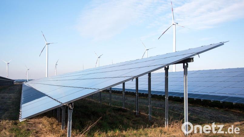 Blick auf einen Solarpark, im Hintergrund sind Windräder zu sehen. Bild: Daniel Bockwoldt/ZB/dpa