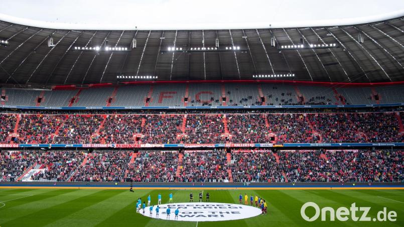 Die Spieler von München und Leverkusen stehen um ein Banner mit der Aufschrift „Beendet den Krieg - Stop the War“. Bild: Sven Hoppe/dpa