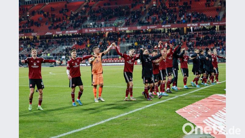 Nürnbergs Team mit dem Torschützen des Siegtreffers Tim Handwerker (4. v.l) jubeln ihren Fan zu. Bild: Löb Daniel/dpa