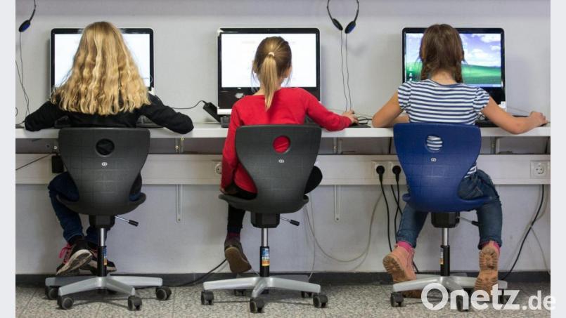 Schülerinnen arbeiten in einem Klassenraum einer Grundschule an Computern. Bild: Friso Gentsch/dpa