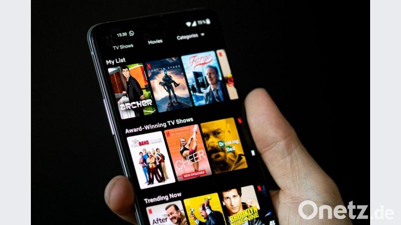 Auf dem Bildschirm eines Smartphones sieht man in der App von Netflix das Filmangebot des Streaminganbieters. Bild: Fabian Sommer/dpa
