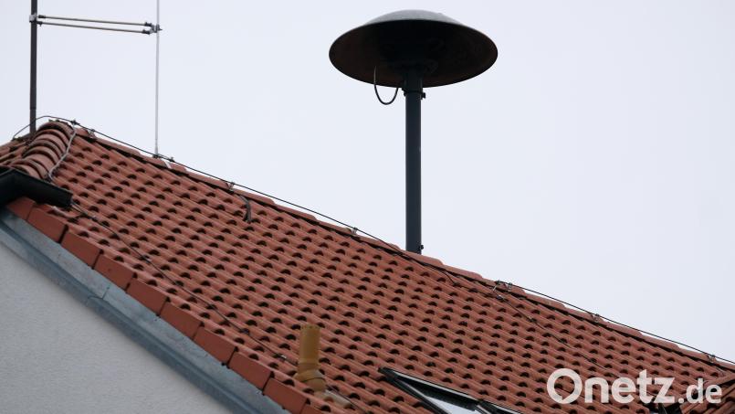 Das Symbolbild zeigt eine Sirene auf dem Dach eines Rathauses. Symbolbild: Stephan Jansen/dpa