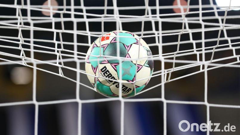Ein Fußball liegt vor der Partie im Netz. Bild: Friso Gentsch/dpa/Symbolbild