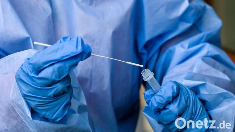 Eine Krankenschwester steckt ein Abstrichstäbchen in die Flüssigkeit eines Corona-Schnelltests. Symbolbild: Jens Kalaene/dpa