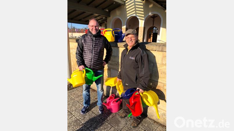 15 neue Fünf-Liter-Kannen helfen nicht nur beim Gießen, sondern machen die Wasserstelle auch bunter. Friedhofswärter Bruno Murr (rechts, mit Benny Walberer) freut sich über die Spende. Bild: ffz