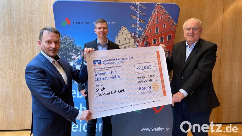 Oberbürgermeister Jens Meyer (von links), Andreas Holz, Leiter der Koordinierungsgruppe Ukrainehilfe und der Präsident des Rotary Clubs Weiden, Lothar Höher, bei der Übergabe des Spendenbeitrags für Flüchtlinge aus der Ukraine. Bild: Stadt Weiden/exb