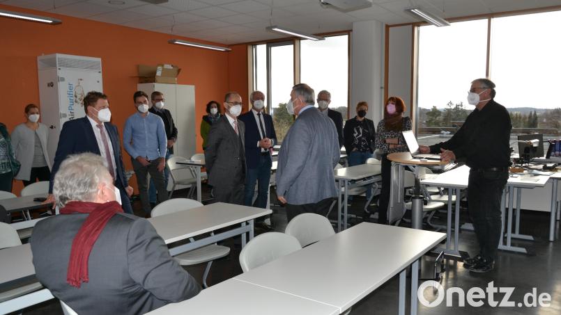 Der Schulausschuss traf sich im Klassenzimmer: Systembetreuer Volker Pfüller (rechts) und Schulleiter Albert Bauer (Fünfter von rechts) führten den Mitgliedern die digitale Ausstattung des Gymnasiums vor. Hinten links ist eines der Luftreinigungsgeräte zu sehen, die in allen Unterrichtsräumen im Einsatz sind. Bild: as
