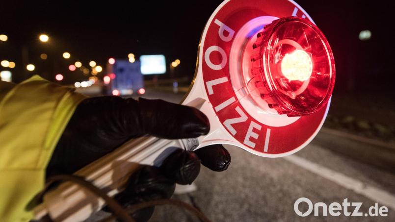 Ein Polizist hält während einer Verkehrskontrolle mit einer Haltekelle Fahrzeuge an. Symbolbild: Patrick Seeger/dpa