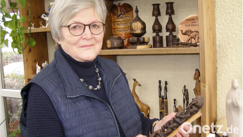 Dr. Annemarie Schraml vor dem Regal an der "Tansania-Wand", in dem Geschenke für die Hilfseinsätze in Afrika aufbewahrt sind – unter anderem ein Lebensbaum, Symbol für das Miteinander in einer Gemeinschaft. Bild: pz
