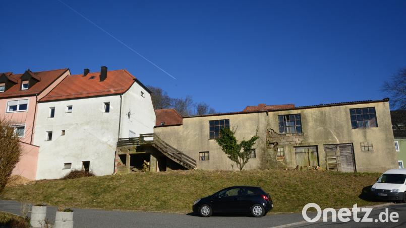 Das alte Werkstattgebäude wird ebenso wie das Wohnhaus (links) abgerissen, im Bereich des Werkstattgebäudes wird der Parkstadel gebaut. Die Einfahrt dazu legt in etwa in Höhe des dunklen Personenwagens. Bild: bey