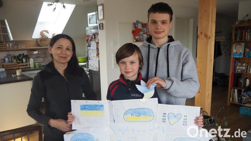 Voller Stolz präsentiert der zehnjährige Aleksander die Bilder, die seine neuen Klassenkameraden in Pfreimd für ihn gemalt haben. Sein älterer Bruder Andrei (rechts) hatte gerade seinen ersten Schultag in der Nabburger Realschule. Zusammen mit ihrer Mutter Valentina Burenko sind die Geflüchteten aus Kiew bei der Familie Eichinger in Pfreimd untergekommen. Bild: bl