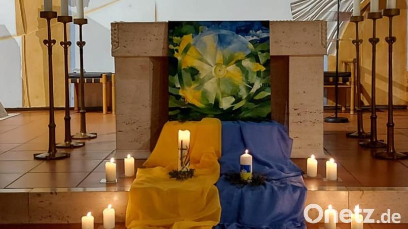 Kerzen und die Landesfarben der Ukraine sind am Altar der Pfarrkirche St. Sebastian Waldthurn beim Friedensgebet aufgebaut. Bild: fvo