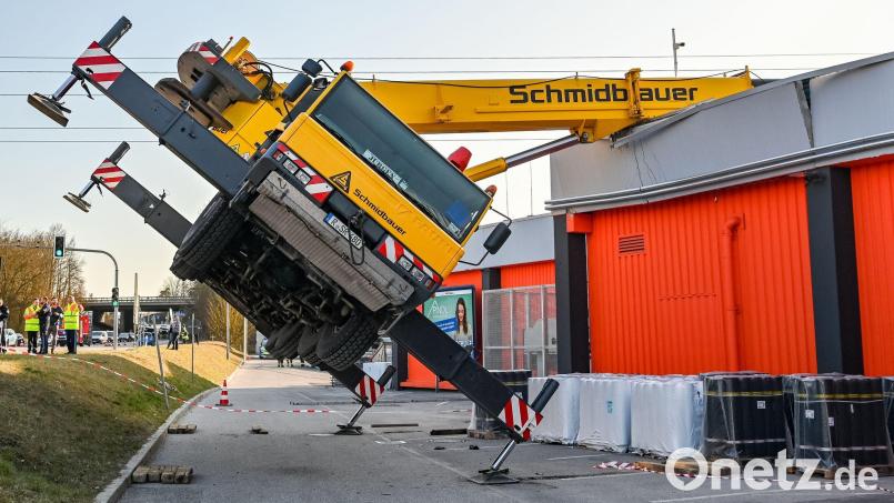 Ein Autokran ist mit seinem Ausleger auf das Dach eines Supermarktes gestürzt. Bild: Armin Weigel/dpa/Archivbild