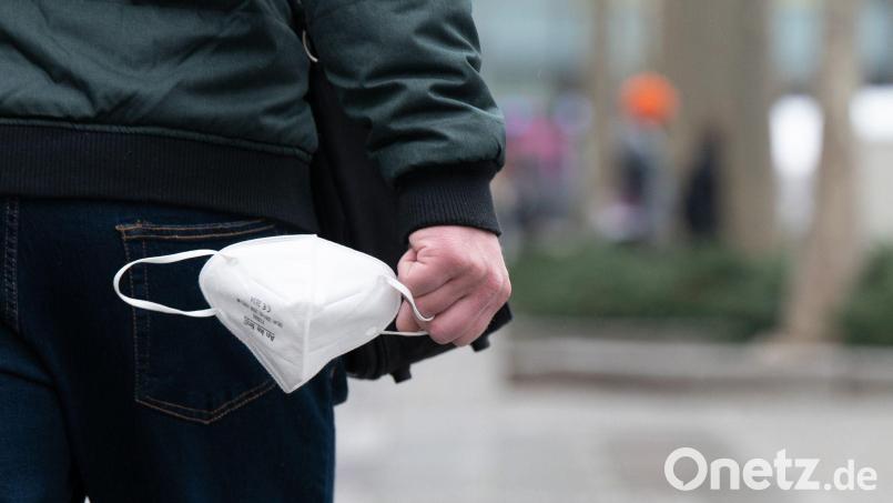 Ein Mann hält eine FFP2-Maske in der Hand. Symbolbild: Sebastian Kahnert/dpa