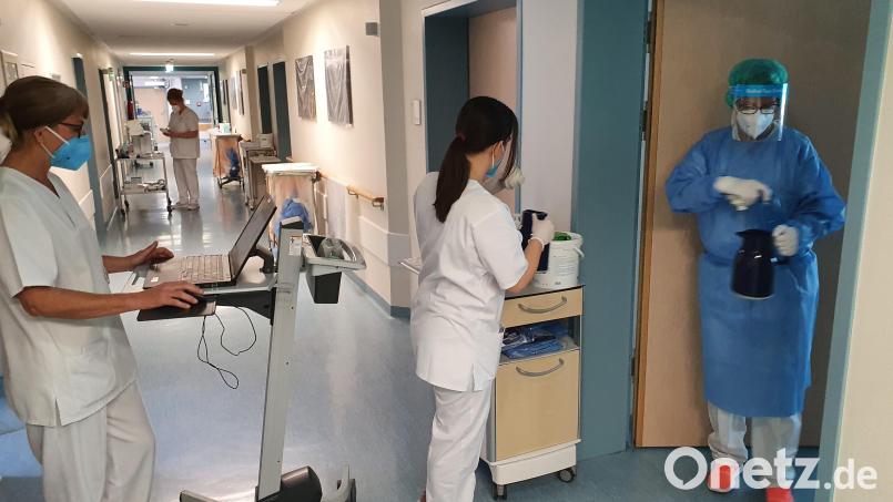 Im Zimmer nur in Schutzkleidung. Von außen unterstützen die Kolleginnen. Bild: Würth, Wolfgang