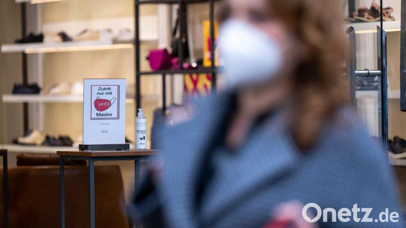 Ein Schild am Eingang eines Schuh-Geschäfts weist auf die Pflicht zum Tragen einer FFP2-Maske hin. Bild: Monika Skolimowska/dpa-Zentralbild/dpa