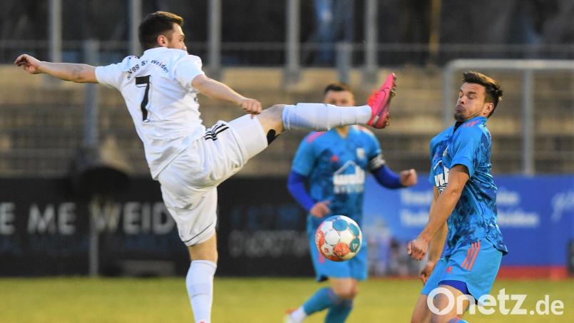 Matthias Heinl (links) geht mit gestrecktem Bein in den Zweikampf: Der Weidener Defensivspieler musste bereits in Halbzeit eins verletzungsbedingt ausgewechselt werden und erlebte die 1:3-Niederlage gegen die SpVgg Osterhofen nur noch als Zuschauer mit. Bild: Büttner
