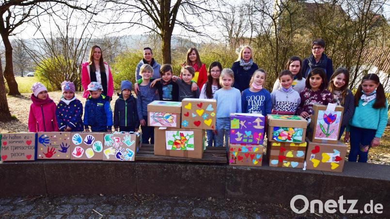 Mädchen und Buben aus der Kita St. Vitus und der Grundschule Illschwang freuen sich mit (von links) Kita-Leiterin Sabrina Stibbe, den Elternbeiratsmitgliedern Daniela Pinzer, Helene Spack und Isabell Ebert sowie Rektorin Gabi Pirner über die bunt bemalten Schachteln mit den gespendeten Materialien. Bild: no