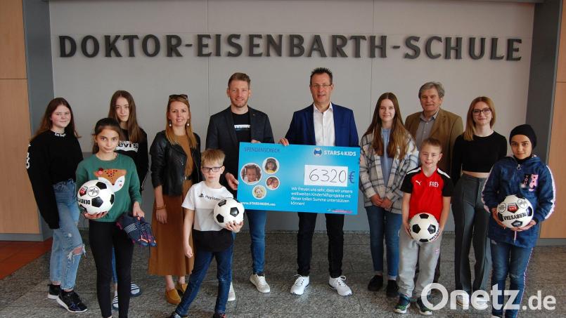 6320 Euro wurden bei der Benefizaktion zur Unterstützung ukrainischer Familien und deren Kinder gesammelt. Voller Stolz präsentieren die Grund- und Mittelschüler zusammen mit (von links) der Grundschulkonrektorin Stefanie Hauser, Konrektor Christian Schreiner, Stiftungsleiter Martin Schäfer und Rektor Werner Winderl diesen stattlichen Betrag. Bild: Doktor-Eisenbarth-Mittelschule/exb