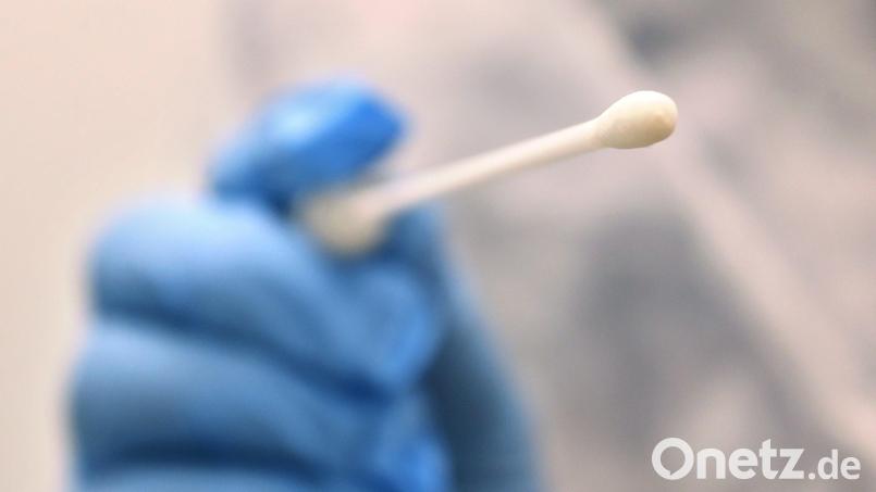 Ein Arzt hält in einer Hausarztpraxis einen Tupfer für einen Coronatest-Abstrich. Bild: Karl-Josef Hildenbrand