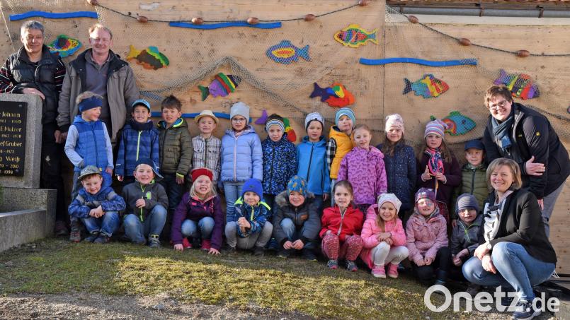 Mit kleinen Kunstwerken verschönerten die Mädchen und Buben der Regenbogen-Kindertagesstätte die Baustellenwand am Friedhof. Dabei erhielten sie auch Unterstützung durch die Schreinerei Haubner und Hans Klupp. Bild: exb