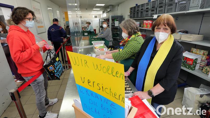 Die Amberger Tafel am Dienstagnachmittag: Nicht nur jene Menschen, die bislang schon Lebensmittel bezogen haben, kommen, sondern auch Flüchtlinge aus der Ukraine, die sich registrieren lassen wollen. Stellvertretende Tafel-Vorsitzende Irmgard Buschhausen (rechts) hat sich als Willkommensgruß für die Geflüchteten einen Schal in den ukrainischen Nationalfarben gestrickt. Bild: Wolfgang Steinbacher