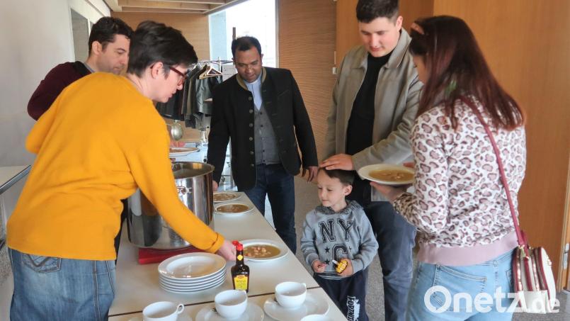 Auch den Gästen aus der Ukraine schmeckt die bayerische Kartoffelsuppe. Pater Robin Xavier (Mitte) wünscht guten Appetit. Bild: rha