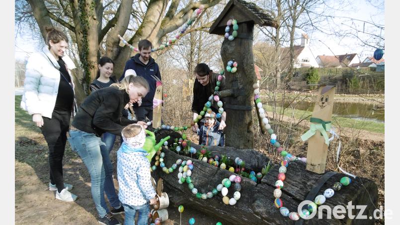Liebevoll schmücken Eltern und Kinder den Osterbrunnen an seinem neuen Platz am Osterbrunnenbach. Bild: mma