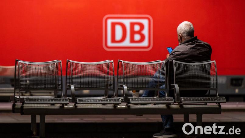 Ein Mann wartet auf einer Bank in einem Hauptbahnhof. Bild: Peter Kneffel/dpa/Symbolbild