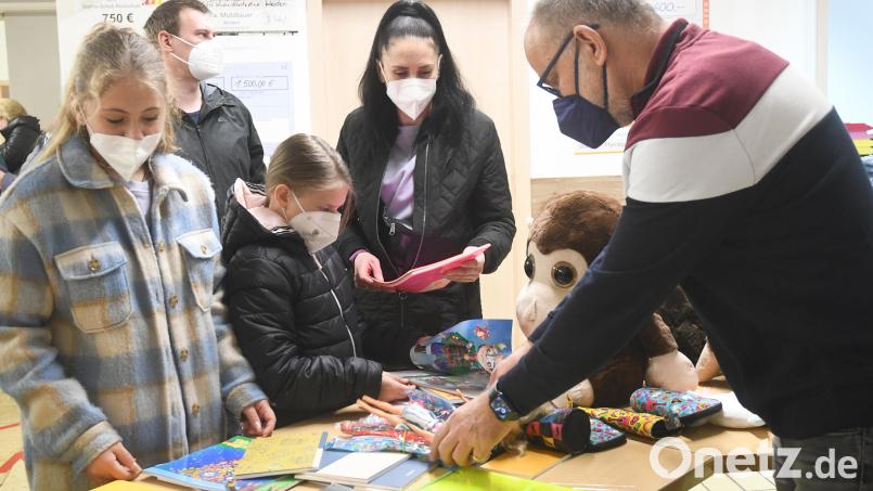Katerina (13), Margarita (9) und ihre Mutter Maryna Soronkina aus Kiew stehen vor Martin Stangls Stand. Der Weidener verteilt Schulmaterial an ukrainische Kinder. Bild: Gabi Schönberger
