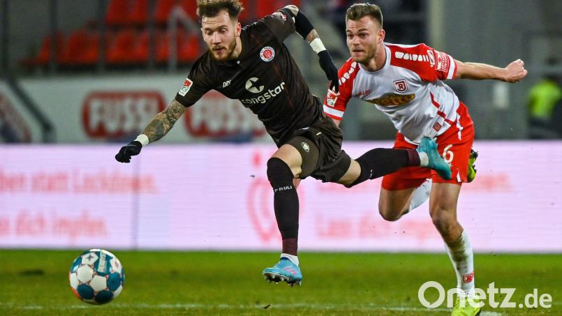 Regensburgs. Benedikt Saller (rechts) verfolgt Marcel Hartel vom FC St. Pauli. Bild: Armin Weigel/dpa