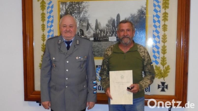 Der Vorsitzende Erhard Neubauer (links) zeichnet Erwin Klemm junior (rechts) mit der Silbernen Verdienstspange des Volksbundes Deutsche Kriegsgräberfürsorge aus. Bild: knh