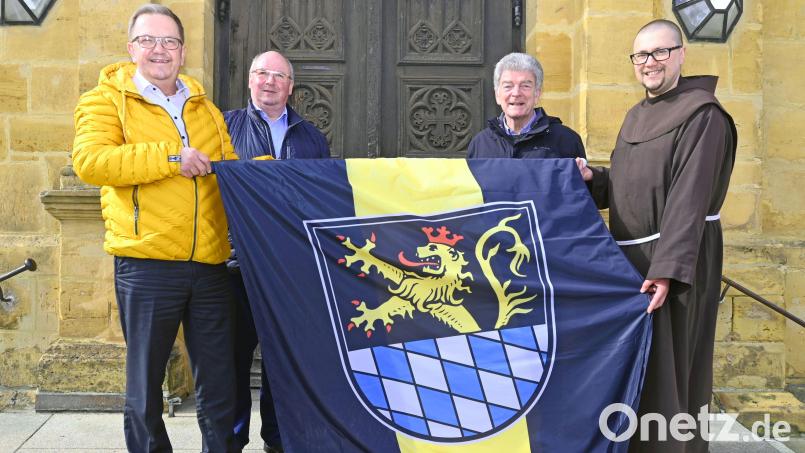 Bürgermeister Martin Preuß (links) überreicht Michael Koller, Franz Mertel und Pater Seraphin Broniowski (weiter von links) die neue Fahne der Stadt Amberg. Bild: Susanne Schwab, Stadt Amberg/exb