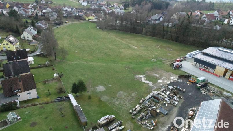 Auf dieser Wiese soll das Gewerbegebiet mit Einschränkungen &quot;Am Bauhof&quot; entstehen. Die Firma Holzbau Riedl (rechts) will dort einen Erweiterungsbau errichten. Die Anlieger am Hopfengarten (links) haben Bedenken. Bild: Walter Beyerlein
