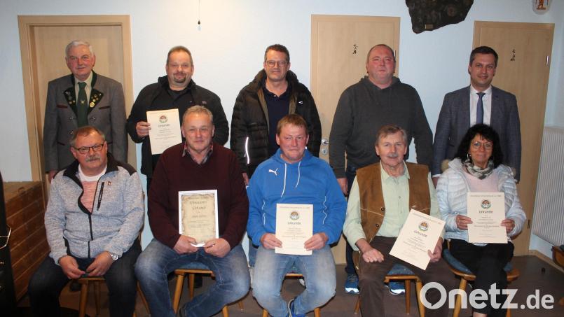 Reinhold Schraml (stehend, links) und Bürgermeister Wolfgang Söllner (stehend, rechts) ehrten Helmut Schenkl, Udo Gebhardt und Roland Weiß (stehend, Zweiter bis Vierter von links) sowie (vorne, von links) Reinhard Zaus, Anton Kellner, Thomas Schmidt, Horst Ritter und Margit Graf. Bild: soj