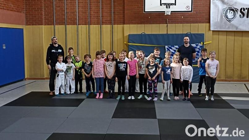 Andi Fachtan (links) und Florian Hoffmann (rechts) mit den Kindern beim Selbstverteidigungskurs in der Schulturnhalle. Bild: soj