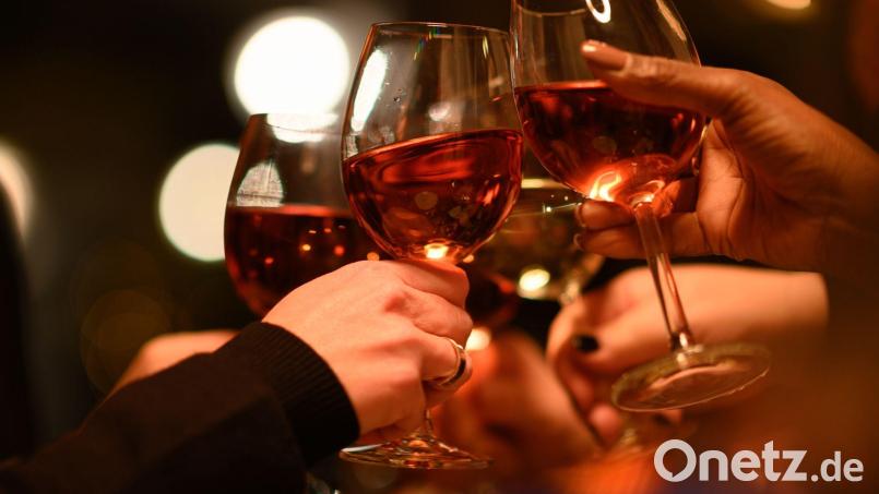 Gäste stoßen in einem mit ihren Weingläsern an. Bild: Robert Michael/dpa-Zentralbild/dpa/Symbolbild